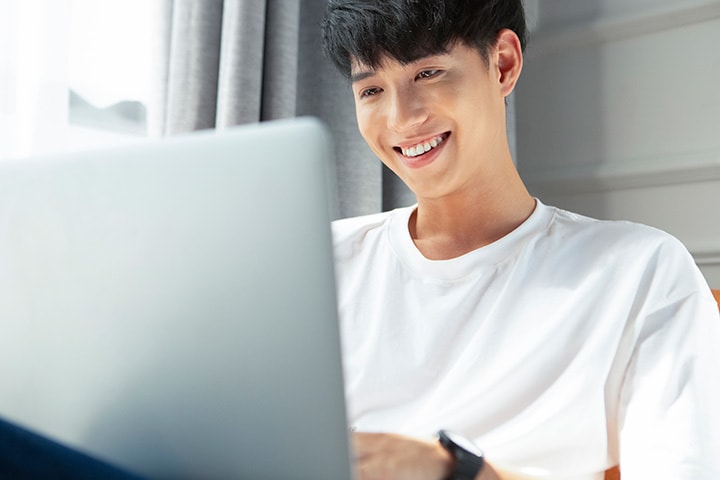 定期的に追加される様々なボイトレ&レッスン動画をパソコンでチェックする男性