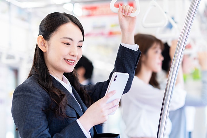 電車の中で発声をせずにボイトレ＠マスターの動画レッスンを視聴する女性